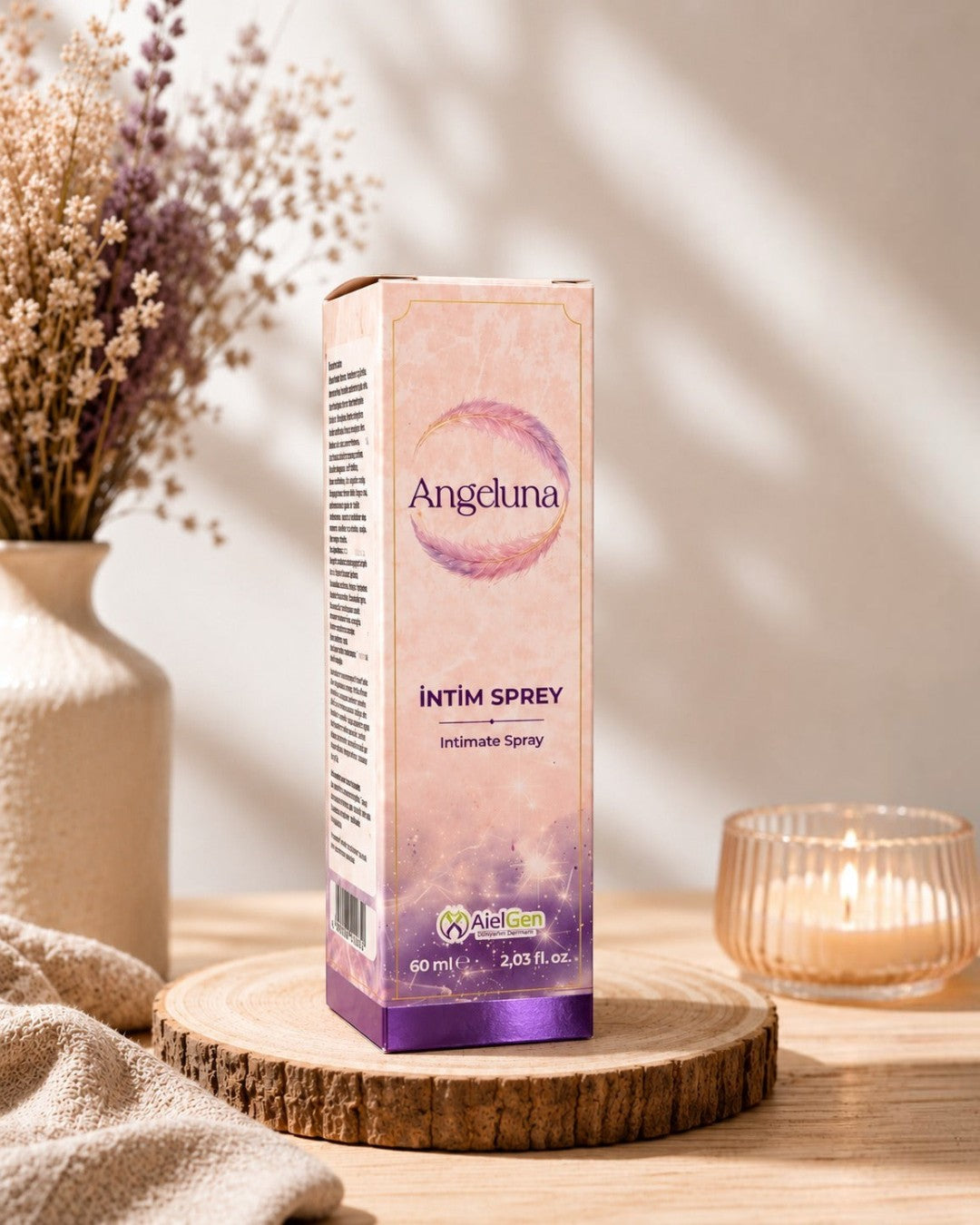 AlelGen Angeluna 60 ml dış genital bölge bakım spreyi, şık kutusunda, ahşap zemin üzerinde dekoratif vazo ve mum ile.